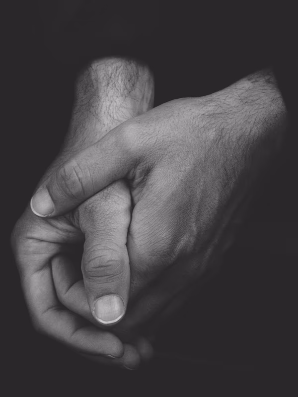 Two hands gently holding each other in black and white - the quality of touch the work begins with