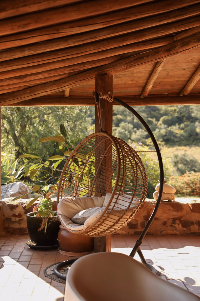 Rattan hanging chair on the veranda, valley greenery behind