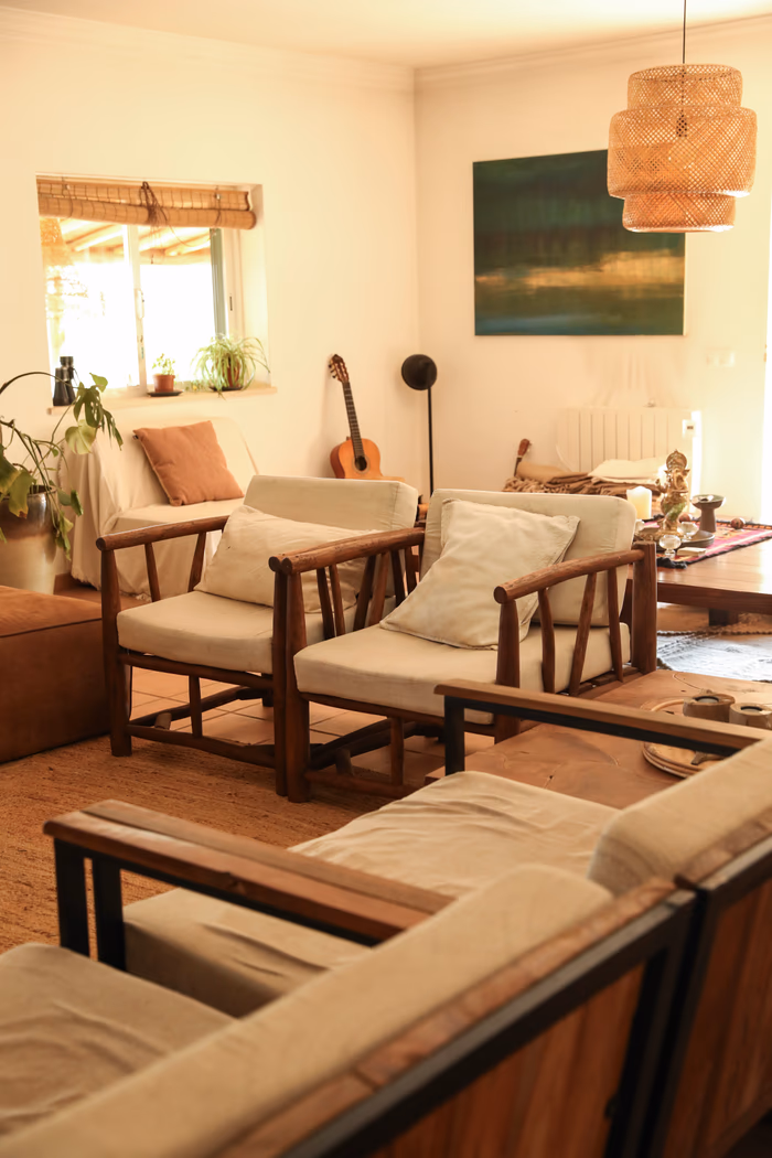 Rattan armchairs, a guitar and warm afternoon light in the villa living room
