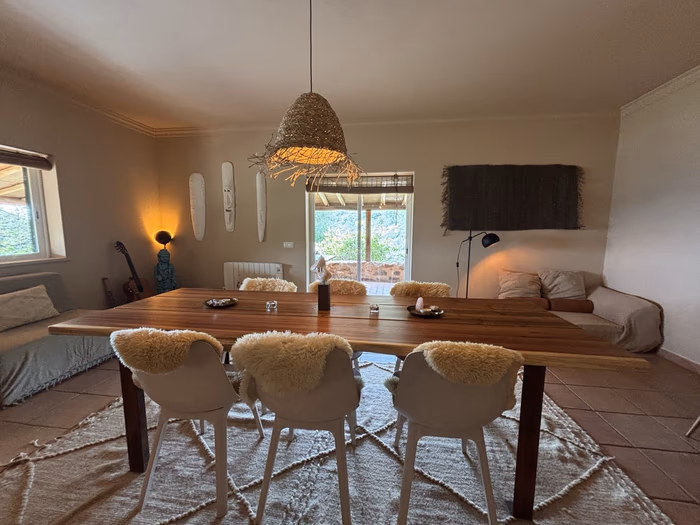 The living room table with sheepskin chairs and soft evening light
