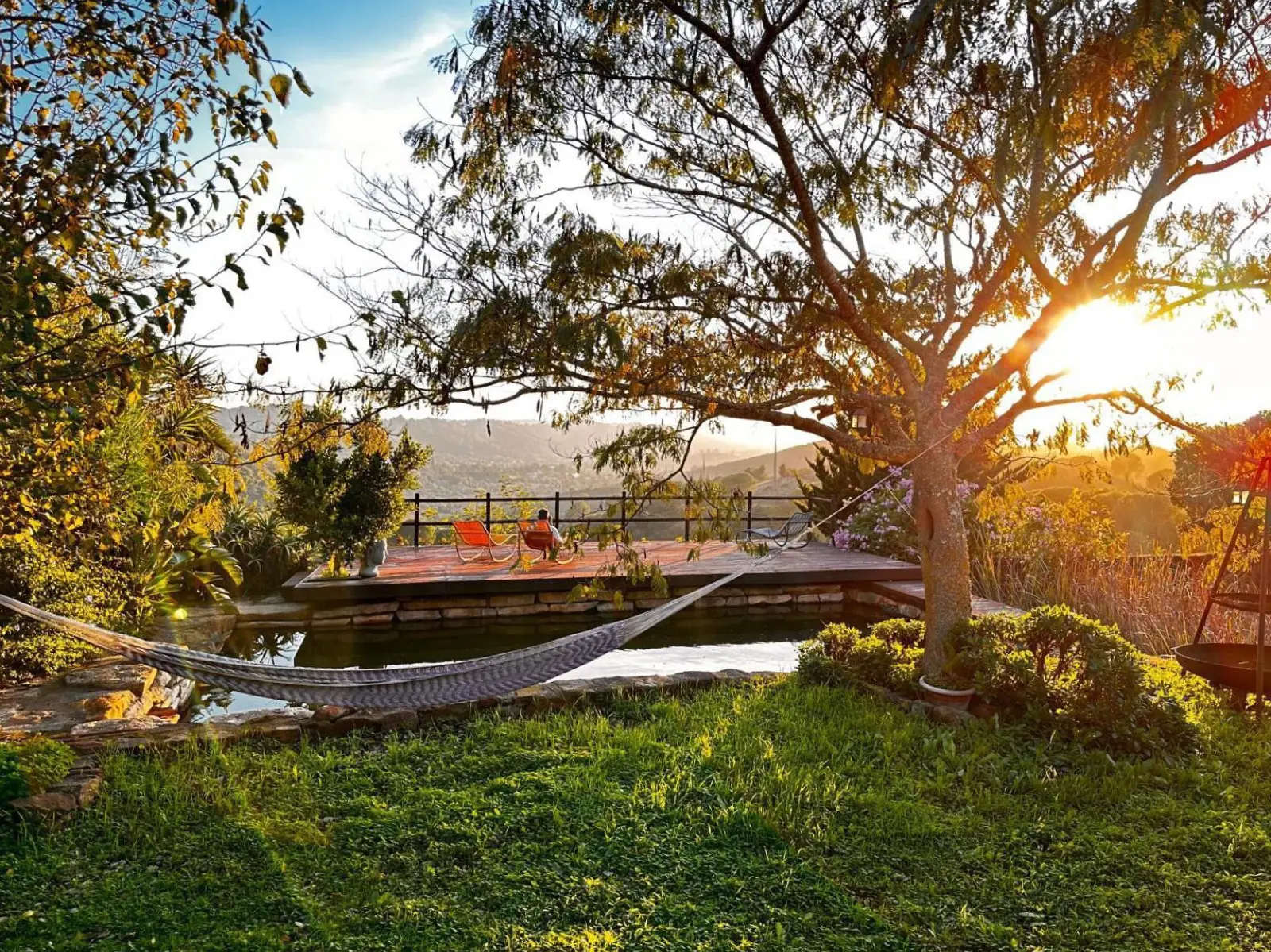Hammock and terrace above the natural pool at Rose Mountain, valley sunset behind