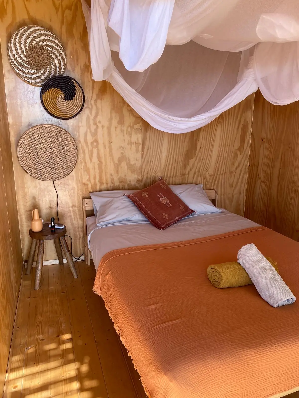 Tiny house double bedroom - plywood walls, woven wall decor and canopy net